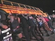 Members of the Millionaires and Misfits then walk to the bus and lift it on its side.