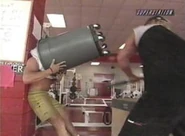 Lex Luger putting a trashcan over the head of Chuck Palumbo.