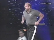 Arn Anderson rushes to the ring as the Four Horsemen music plays.