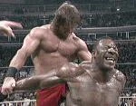 Chris Benoit applying a surfboard to Booker T.