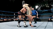 Rey Mysterio utilizing a head scissors on Billy Kidman.