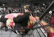 Goldberg spears Rocco Rock through a table.