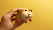 A photograph of a hand holding Potato's wool felt puppet