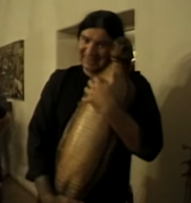A behind the scenes photo of effects artist holding the snake prop.