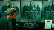 Jack standing next to a wall plastered with Stonecrow posters.