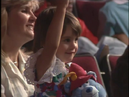 A little girl holding a Tummi plush bear from Gummi Bears