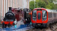 An S8 Stock train alongside two Metropolitan Railway steam locomotives.