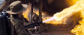 A Tatmadaw soldier torching a village with a flamethrower.