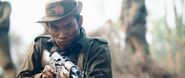 A Tatmadaw soldier aims an AKM at the mercenaries.