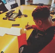 Kodigo firmando un contrato con Warner Music.