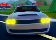 The front view of the Challenger with its headlights on.