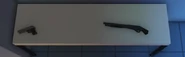 The weapons table, with the pistol and shotgun on it.