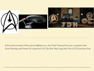 Flowers and a glass painting of the Starfleet Logo and U.S.S Enterprise from Star Trek