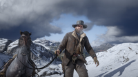 A bearded Arthur leading his horse through the cold climate of the Grizzlies.