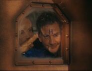 Rimmer waves goodbye to Lister through the porthole