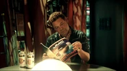 Lister reading the magazine before being knocked out by his future self ("Give & Take", Series XI)