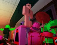 Reddy standing on a drumset.