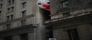 A clown balloon between 2 brown buildings[3]