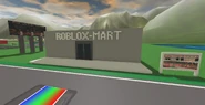 A light gray building with blocky, white text on the front reading "ROBLOX-MART".