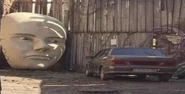 A statue's head in front of a car.