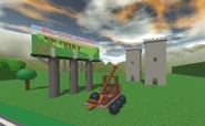 A billboard next to a loaded catapult aimed at two fortified towers.