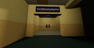 A staircase next to the room with a sign above it reading "Konferenzräume".