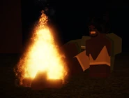 Sarah sitting at a campfire deep in the woods.