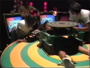 A behind the scene footage of a contestant getting strapped into the wheel.