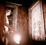 Маргарет ходит с фонарём по дому.