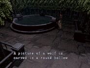 A picture of a wolf is carved in a round hollow. (Resident Evil)