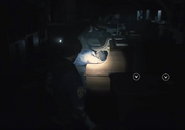 Possibly George Scott sitting dead in his chair at his desk in the Resident Evil 2 (2019)