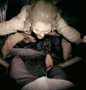 Маргарет-мутант хватает Итана и поднимает вверх.