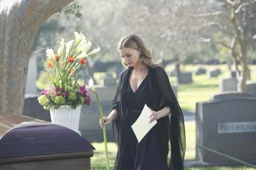 Emily holds a flower near Amanda's grave