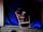 A Young Man Dressed As A Gorilla Dressed As An Old Man Sits Rocking In A Rocking Chair for 56 Minutes and Then Leaves