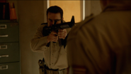 The Patriot officer is aiming his gun at Connor, who is holding Truman hostage.