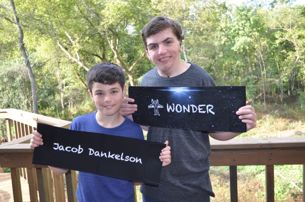 Peter and Jacob Dankelson hold up Wonder movie set signs