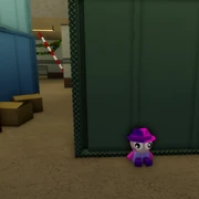 Behind the big metal crates.