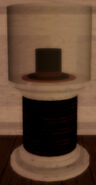 A top hat in a cylinder display case.