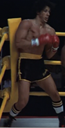 Rocky in The Superfight II, the rematch against Apollo Creed, with the first Italian Stallion costume (black and gold) seen in Rocky II and Rocky III.