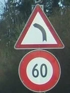 Panneau d'annonce d'un virage à gauche accompagné d'une limitation de vitesse. © Marcel Monterie