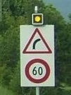 Panneau d'annonce de virage à droite accompagné d'une limitation de vitesse et d'un feu d'alerte clignotant. © Marcel Monterie