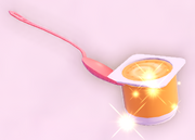 A spoon and a tin of apricot yogurt.