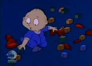 Tommy gets out of his crib and crawls to his building blocks...