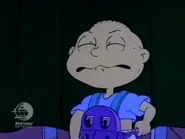 Tommy unsuccessfully tries to pull the baby suspenders off again