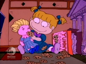 A two-year old Angelica eating cookies with her ragdoll