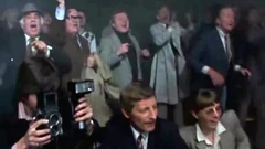 Джон Уильям Олт (первый слева) в роли зрителя боксёрского матча («Механик»)