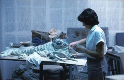 Скульптор  создаёт каменного бородавочника.