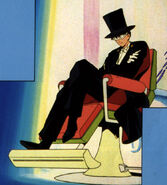 Tuxedo Mask sitting in a chair