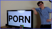 Scott leaning on his TV with the word "porn" on it