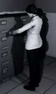 Image of what appears to be a female scientist looting cabinets in the SCP:SL trailer.